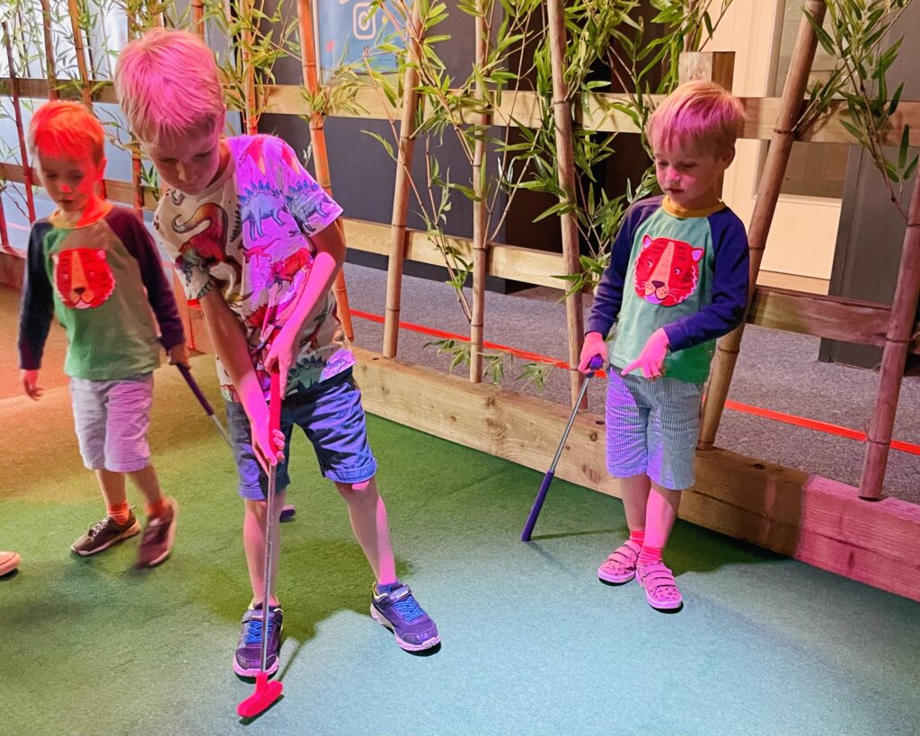 Brothers play golf at Paradise Island Adventure Golf on a family day out at Drake Circus in Plymouth and a great way to entertain your kids