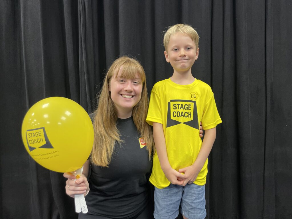 Stagecoach teacher Ellie and six year old pupil with a yellow balloon