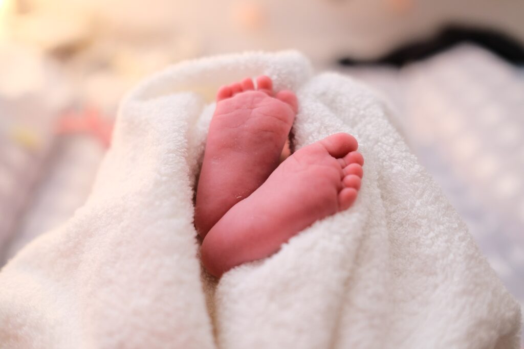 Choosing your baby's name - a newborn baby feet wrapped in a blanket for a newborn baby essentials checklist