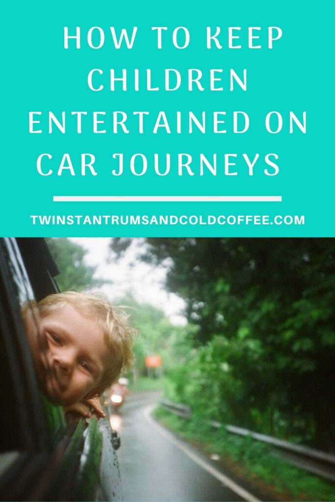 boy poking his head out the window on a car journey