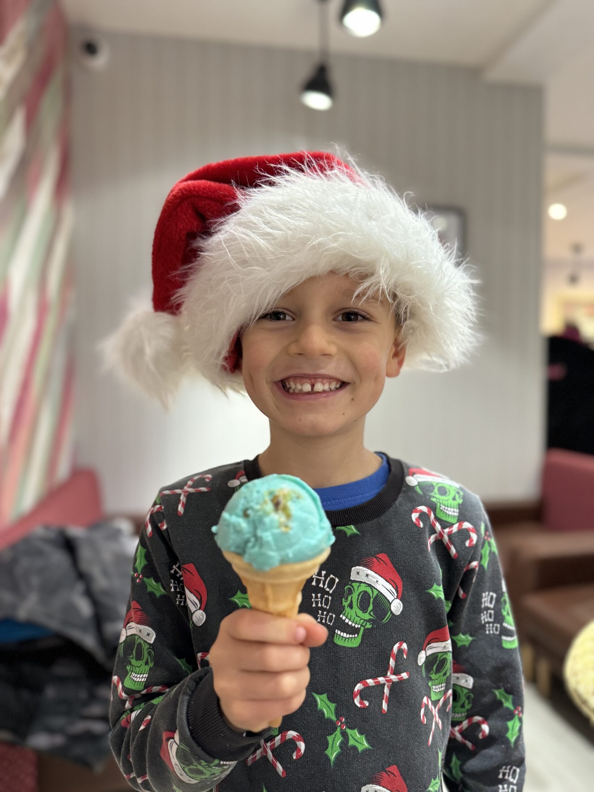 Little boy with santa hat eating an ice cream