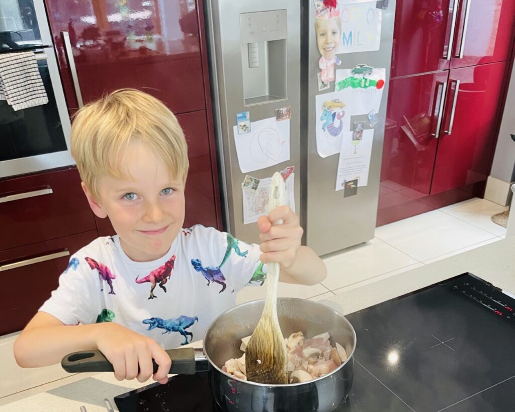 Six year old boy makes a meal in a kitchen as one of his chores