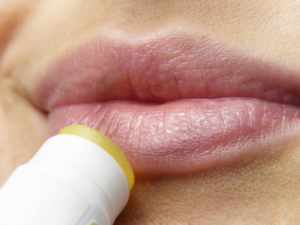 Close up of lips having lip balm put on them as a beauty essentials