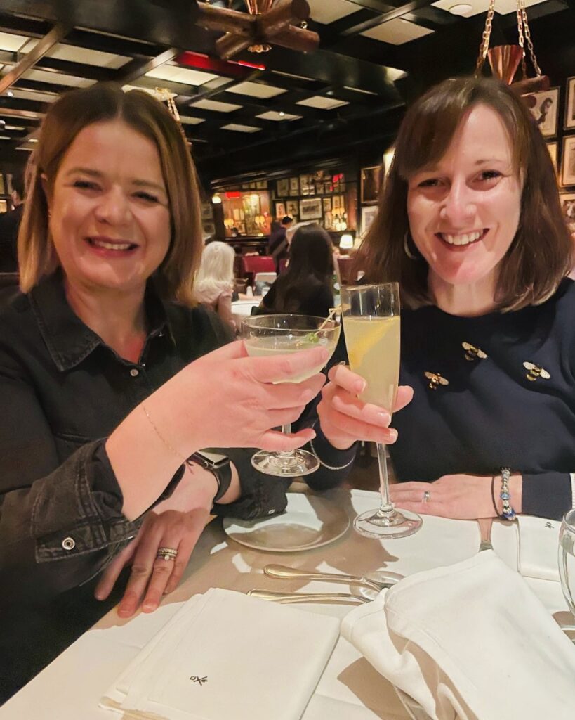 Two friends with drinks in a steak bar in Manhattan