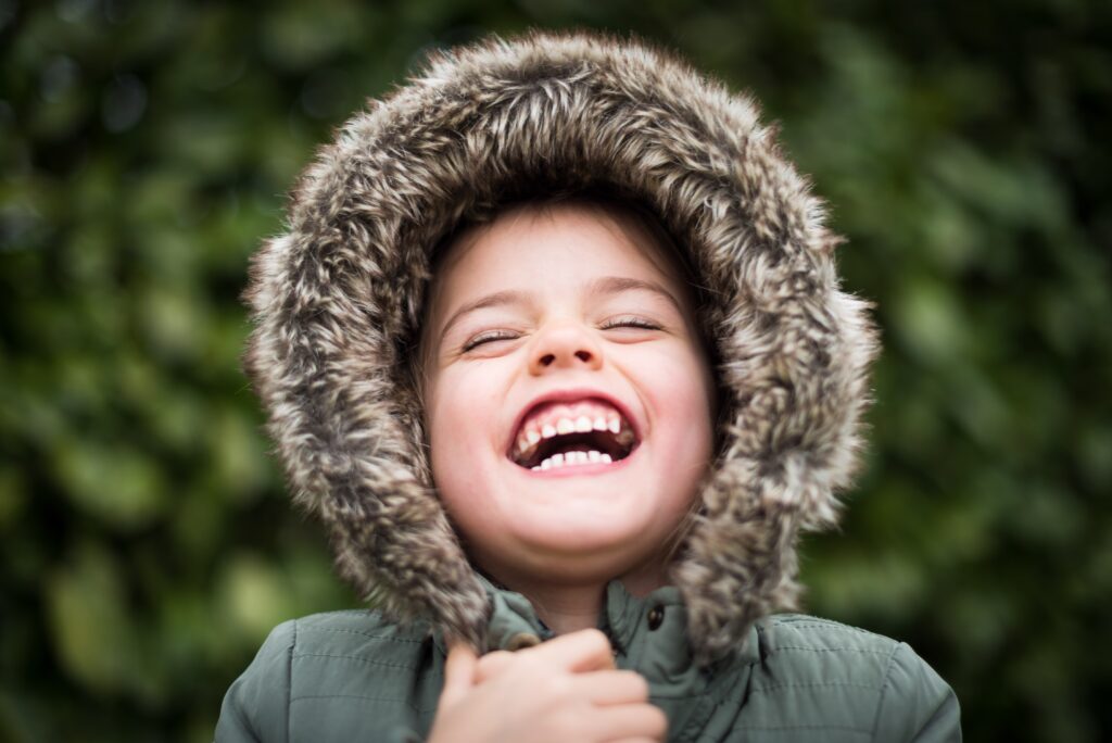 A child smiling widely, for a post on how to take care of your child's teeth