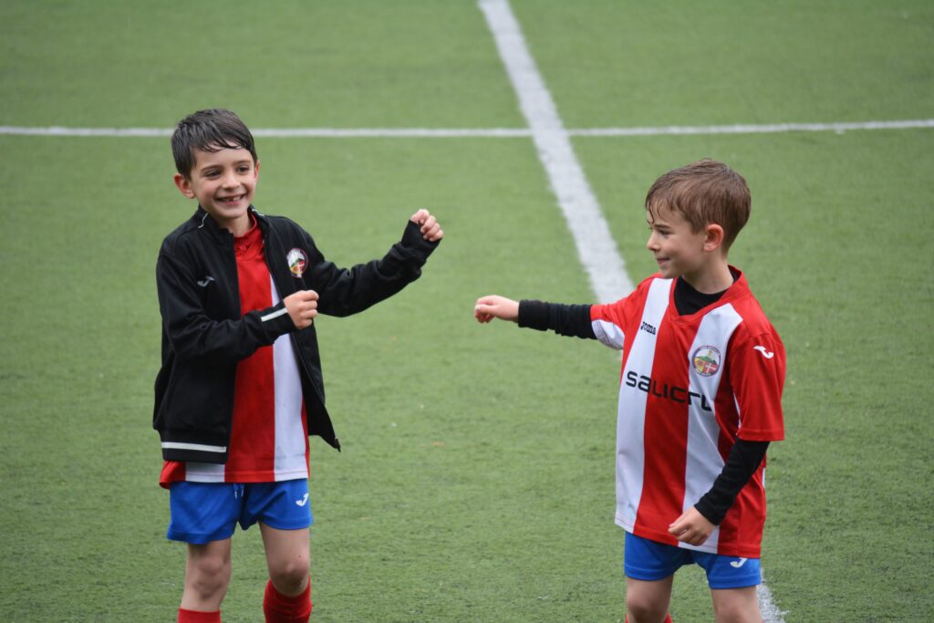 Two boys play football and learn how to become a team player