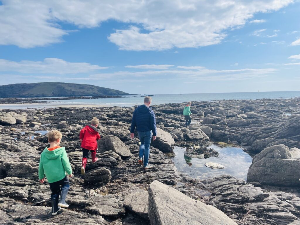 Three boys and dad at Wembury beach rockpools