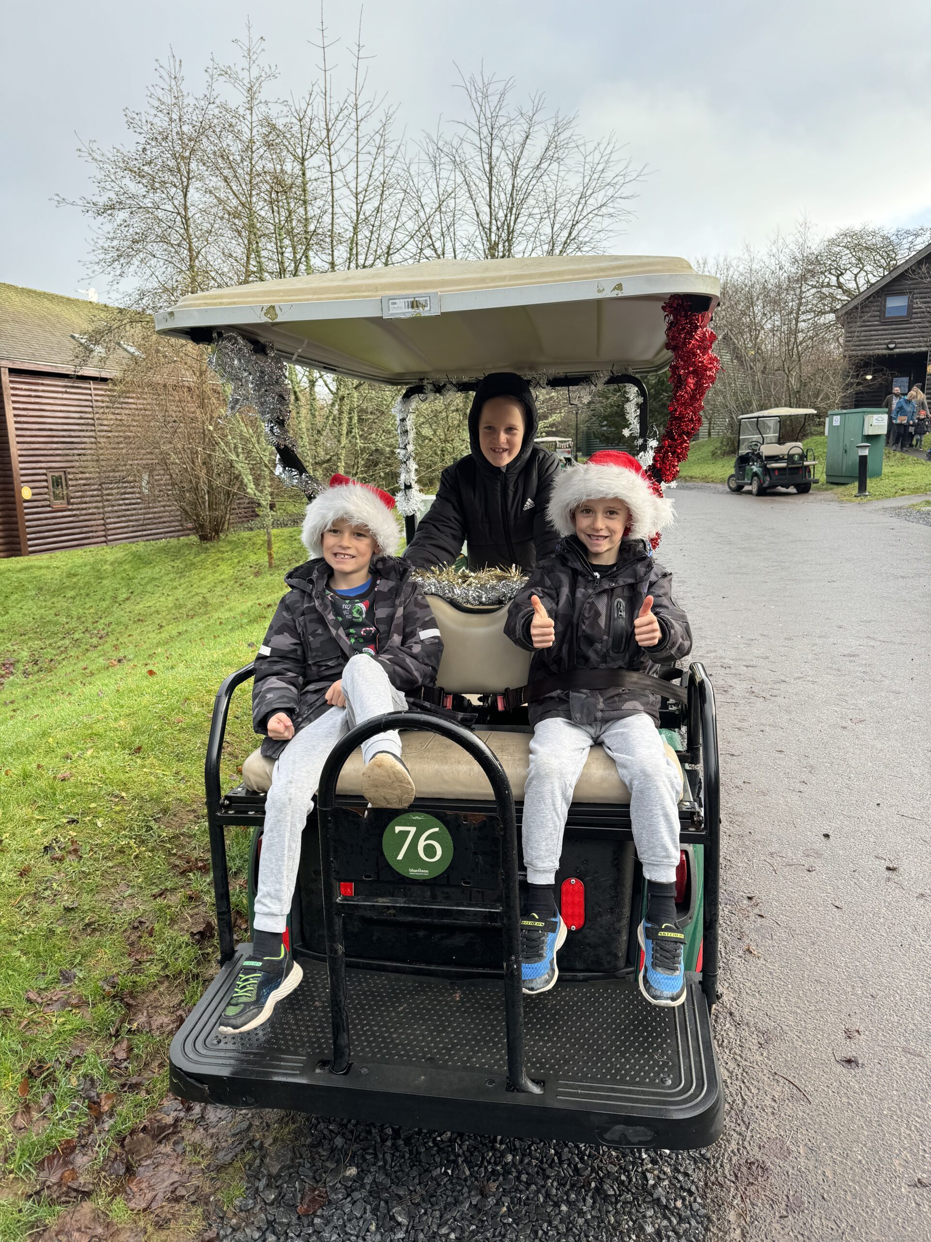 Three boys on the back of a golf buggy at Bluestone