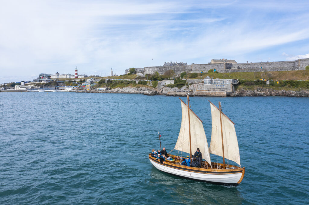 A yacht in Plymouth Sound in front of the Hoe